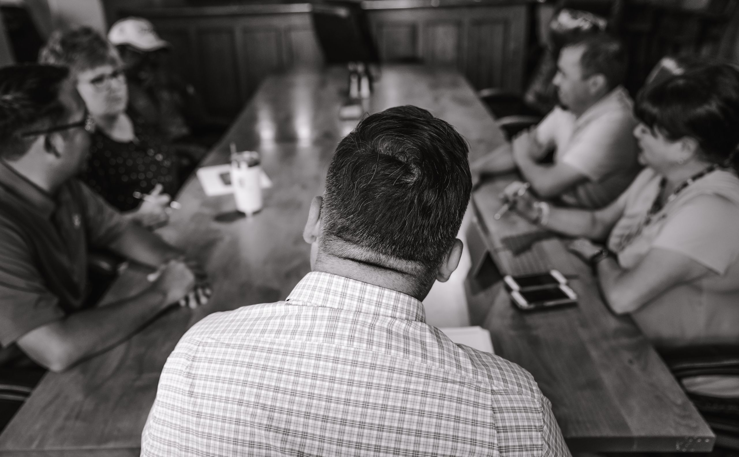 A group of professionals engaged in a discussion in a conference room.